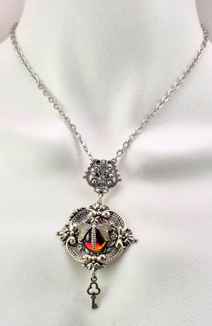 Antique Art Glass cabochon with varying colour display including amber and purple. The back side of the pendant is decorated with an antique watch face unique to each piece.