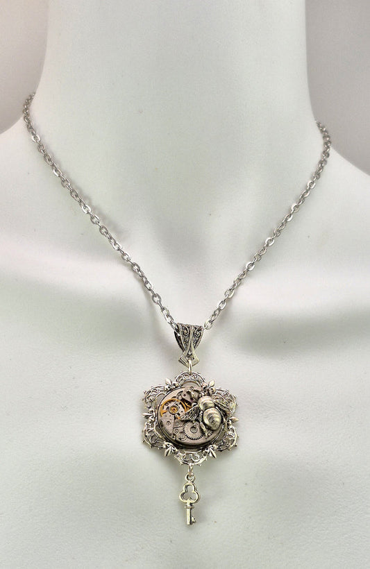 Sterling silver filled Victorian antique or reproduction work from original mold. The pendant features an ornate silver filigree design surrounding a vintage clockworks embellished with a bee.
