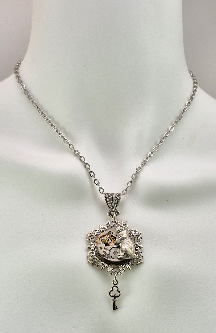 Sterling silver filled Victorian antique or reproduction work from original mold. The pendant features an ornate silver filigree design surrounding a vintage clockworks embellished with a rabbit.