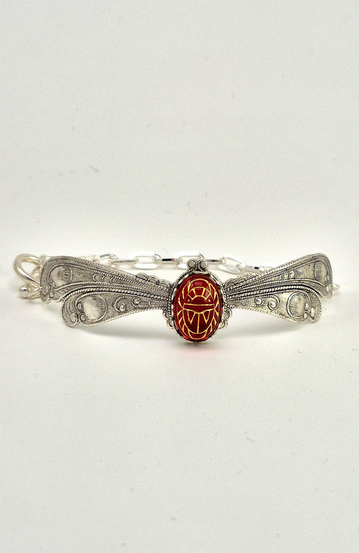 Sterling silver filled Victorian antique or reproduction work from original mold. The bracelet features a silver dragonfly wing design surrounding a central bright ruby coloured antique Art Glass cabochon with an etched scarab design.