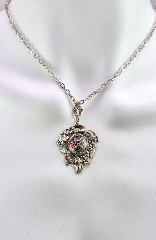 Sterling silver filled Victorian antique or reproduction work from original mold. The pendant features a silver vine design surrounding a central bright green & red iridescent antique Art Glass cabochon with a crescent moon motif.