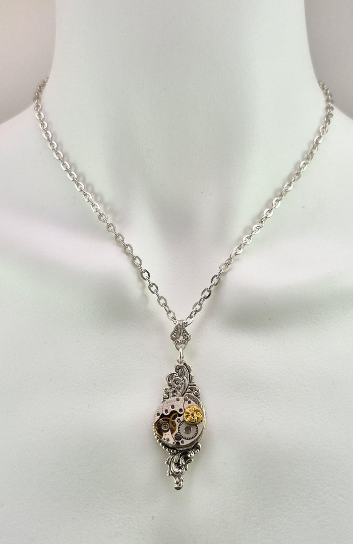 Sterling silver filled Victorian antique or reproduction work from original mold. The pendant features a silver floral design surrounding a vintage watch works embellished with a brass moon.