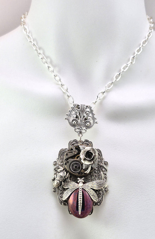 Sterling silver filled Victorian antique or reproduction work from original mold. The pendant features an ornate silver filigree design celebrating Monet's painting The Artist's Garden surrounding a central lavender with golden hue antique Art Glass cabochon with a dragonfly motif.